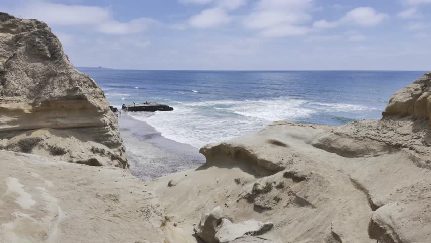 San Diego California Torrey Pines State Reserve cliffs with view of the Pacific Ocean with small waves and rocks.