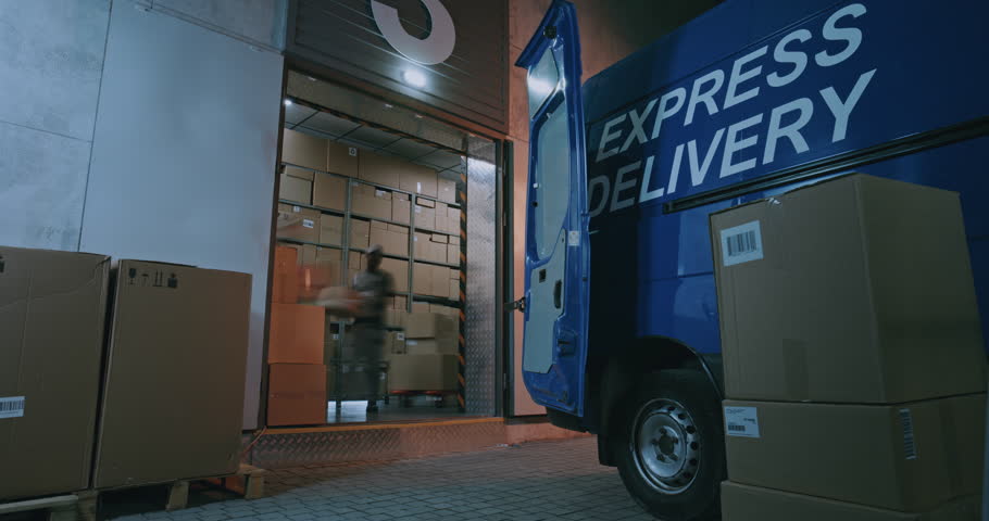 Outside of Logistics Distribution Warehouse at Night: Team of Diverse Employees Loading Delivery Truck with Cardboard Boxes with Online Orders, Goods. Express Delivery Service. Full Shot. Time Lapse.