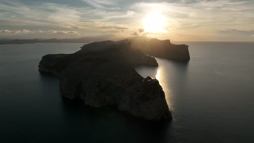 A Drone view of Formentor Lighthouse perched on a cliff at sunset in Tramuntana mountains, Mallorca, Spain
