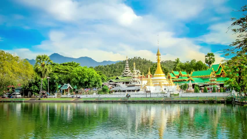 A serene temple reflected in the lake under a cloudy sky
