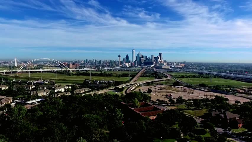 The dallas skyline rises above the landscape with bridges and highways
