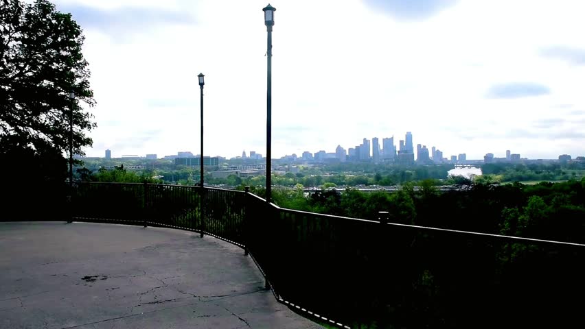 A distant cityscape is visible from an overlook point