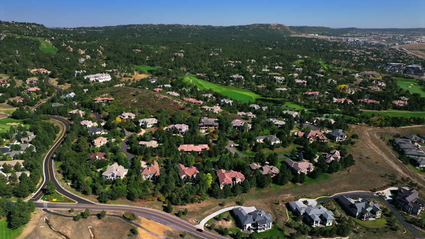 Castle Pines Village spring aerial drone Colorado Daniels Park BMW Championship Golf Course front range morning gated community neighborhood homes blue sky cars roads forward motion