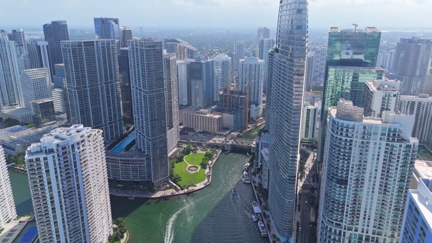 Skyscrapers Of Downtown Miami In Florida, Flanking Miami River In Daytime With Foggy Background. aerial pullback shot