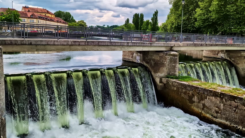 Cascading water over Ludwigswehr Dam and small bridge on Isar River in Landshut, Germany
