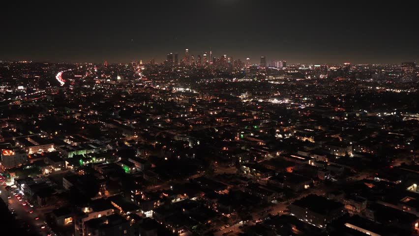 Wide tilting-up aerial shot of downtown Los Angeles under a full moon in Southern California. 4K