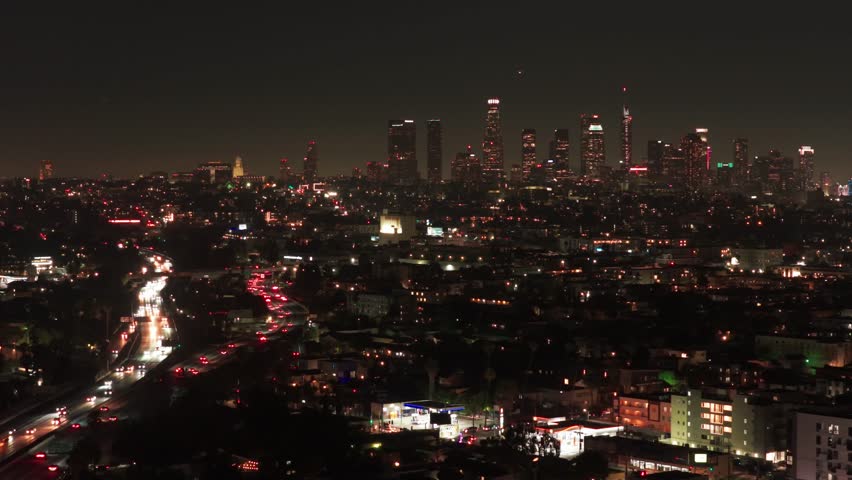 Aerial wide panning shot of Highway 101 towards downtown Los Angeles at night in Southern California. 4K