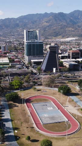 Drone shot overlooking La Sabana Metropolitan Park and surrounding buildings including Republic General Comptroller in San Jose, Costa Rica. Vertical Video