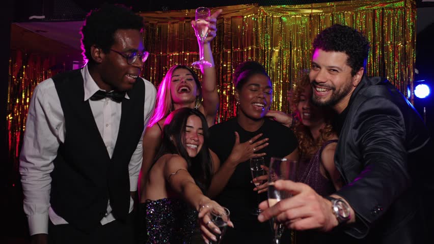 Friends toasting at photo booth party in slow motion