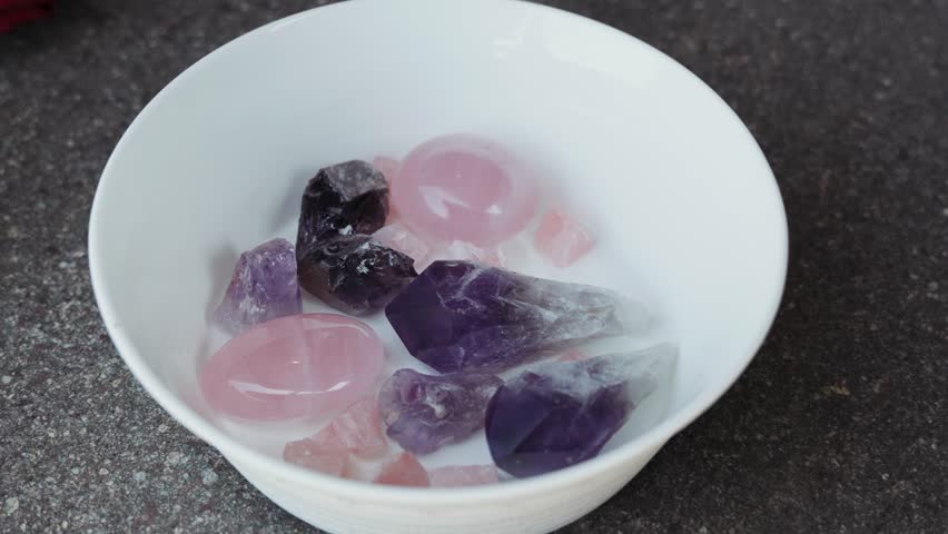 Amethyst, rose quartz, and smoky quartz stones arranged for a spiritual Neo-Pagan wedding ritual