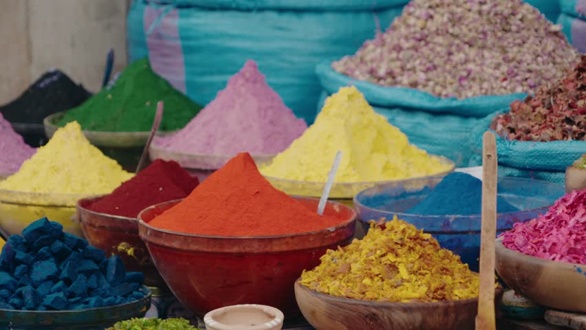 Colorful spices and dyes at a Moroccan market. This vibrant display showcases the rich culture and traditions of Morocco. The colorful powders and dried petals create a feast for the eyes,
