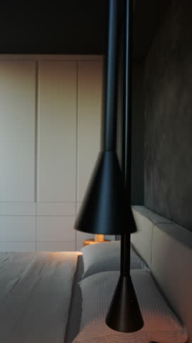 Modern bedroom interior design with minimalist style. Stylish black pendant lamps hang over a bed with white linens. Soft lighting creates a relaxing atmosphere, perfect for unwinding after a long day