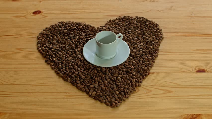 Pouring Traditional Turkish Coffee into a Cup Surrounded by Coffee Beans in Heart Shape