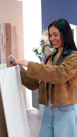 Customer comparing countertop materials, using smartphone for information and inspiration in a home improvement store