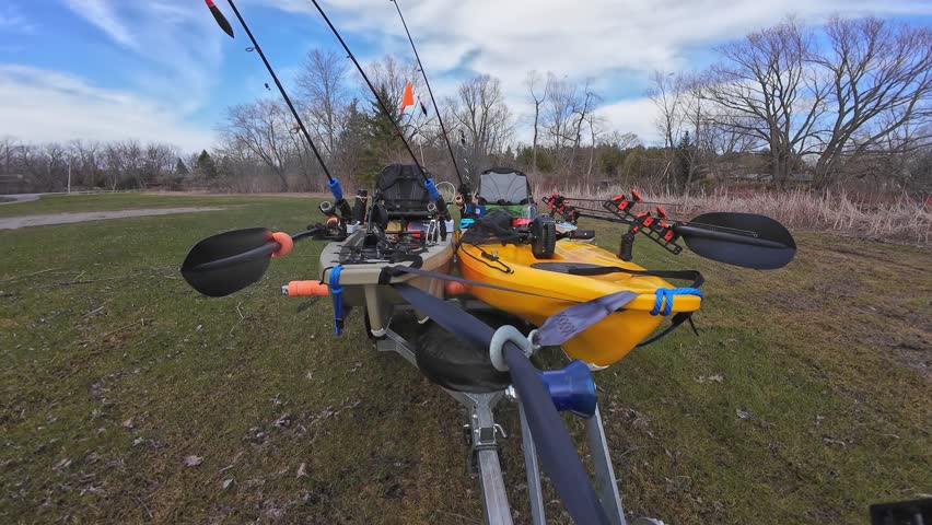 Truck pulling boat trailer with fishing kayaks. Water sport and fishing. Boat launch at lake in the wilderness. Boat trailer with fishing kayaks near drop off at the lake.