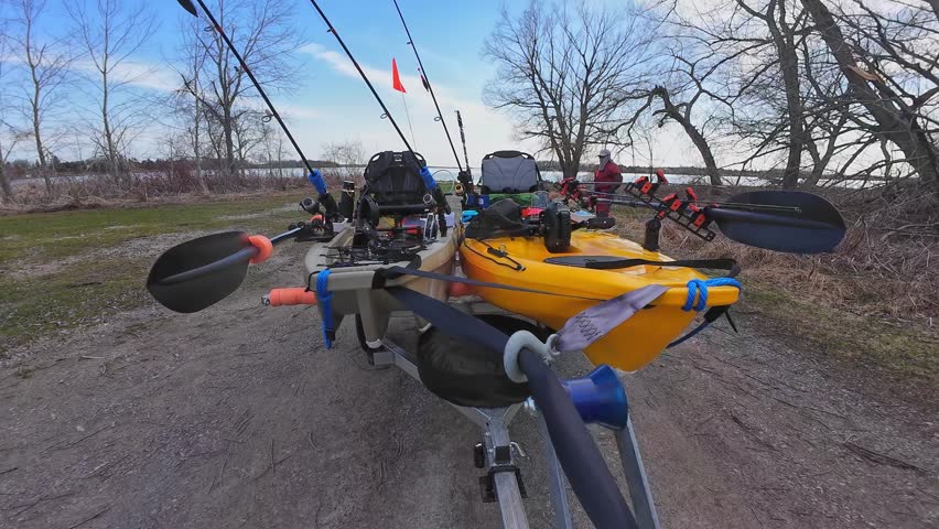 Truck pulling boat trailer with fishing kayaks. Water sport and fishing. Boat launch at lake in the wilderness. Boat trailer with fishing kayaks near drop off at the lake.