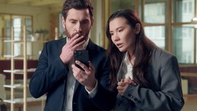 Shocked stressed Caucasian Korean workers afraid use mobile phone losing deal bad news at office shock upset business man woman frustrated entrepreneur businessman businesswoman smartphone sms message - Powered by Shutterstock - Get 15% off with code: PIKWIZARD15
