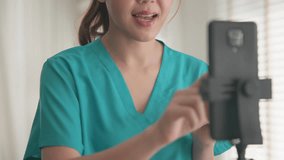 Young adult woman Gen Z asia people anti aging expert modern nurse live talk viral video selfie camera on mobile phone app mental health care. Online sharing digital virtual asian vlogger filming. - Powered by Shutterstock - Get 15% off with code: PIKWIZARD15