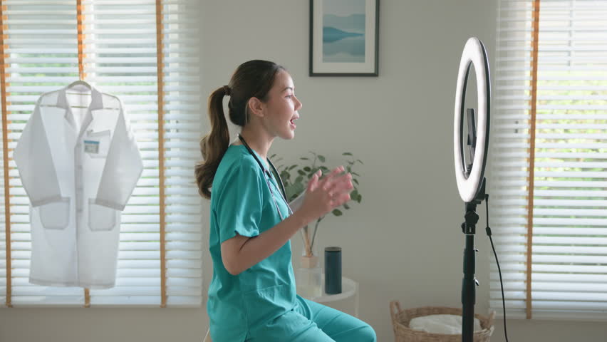 Young adult woman Gen Z asia people anti aging expert modern nurse live talk viral video selfie camera on mobile phone app mental health care. Online sharing digital virtual asian vlogger filming.