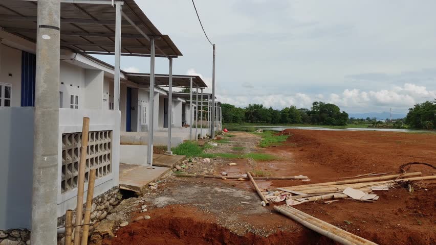 A wide area of open land cleared and leveled in preparation for a residential housing project. The site shows early stages of property development, flat soil and marked sections ready for construction