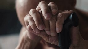 an elderly man sits holding a walking stick with his head down, emotions of old people, a grandfather with a walking stick sits thoughtfully - Powered by Shutterstock - Get 15% off with code: PIKWIZARD15
