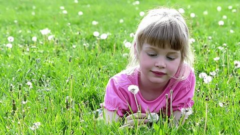 Little girl blowing dandelion, slow motion, high speed camera