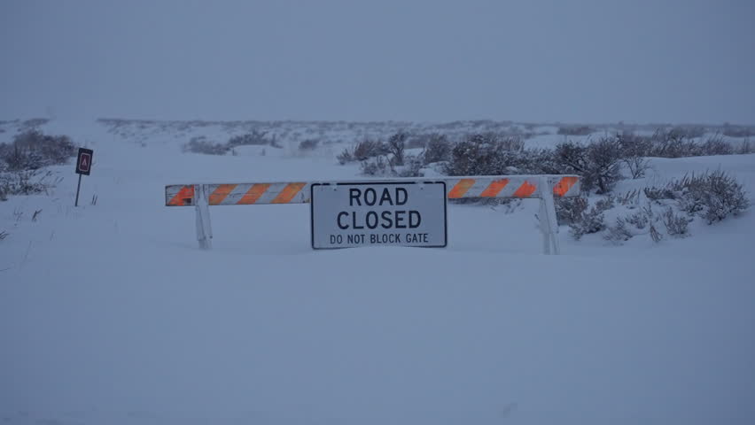 Road closed sign in snow-covered wilderness