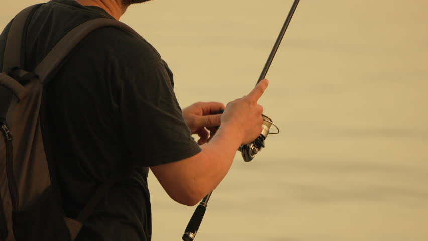 Fisherman With a Backpack and a Fishing Rod