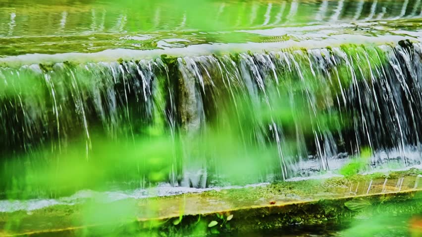 Slow motion of water running down the stone step