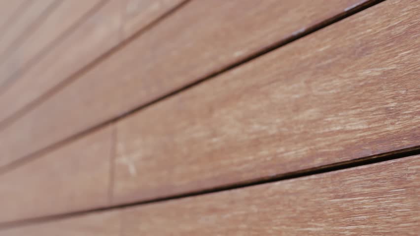 Close-up of a house wall covered with tiles on the facade imitating wood. Modern design. Brick texture. House exterior.