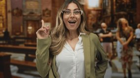 Smiling businesswoman pointing index finger upward inside church interior; faith inspiration devotion reflection. - Powered by Shutterstock - Get 15% off with code: PIKWIZARD15