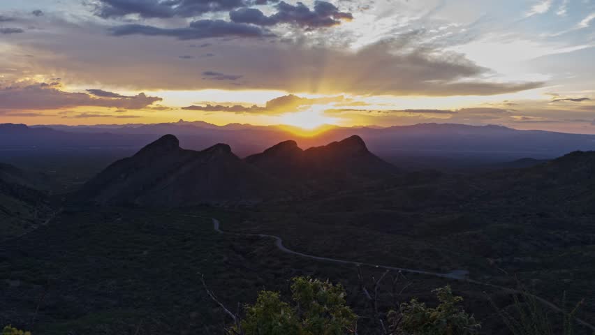 Sunset time lapse with colorful clouds and four mountain peaks
