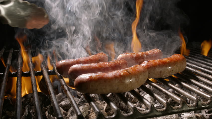Turning Grilled Sausages with Tongs Over BBQ Fire, Slow Motion Close-Up