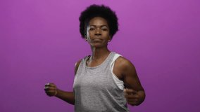 African american woman boxing against an isolated purple background, showcasing energy and fitness through focused expressions and dynamic movements. - Powered by Shutterstock - Get 15% off with code: PIKWIZARD15