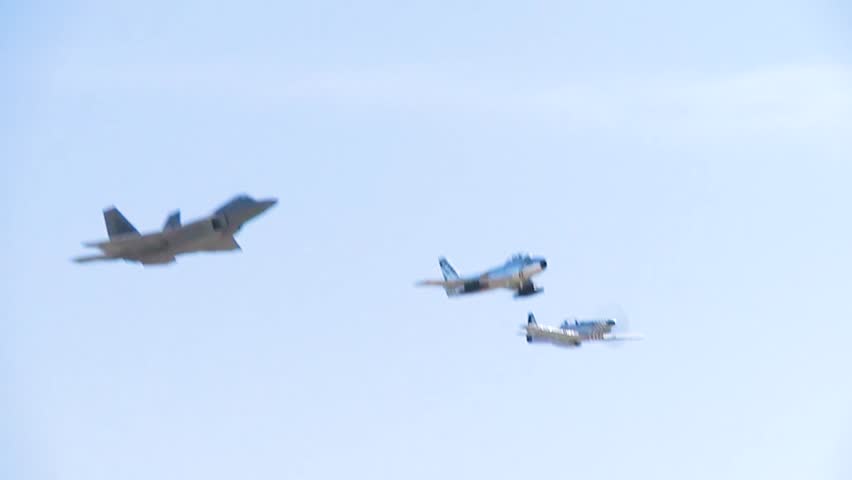 The action of F-22 Raptor fighter jets, P51 Mustang, and F-86 Sabre in an air force demonstration show.