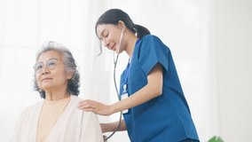 Asian woman doctor examine senior patient use stethoscope listening to the sounds of heart and lungs on the bed. Nurse visit and checking elderly woman health at home. Home medical therapy concept. - Powered by Shutterstock - Get 15% off with code: PIKWIZARD15