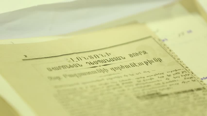 Gloved hands carefully examine old, fragile historical documents and newspaper clippings. Archiving and preserving vintage papers for research, history, and knowledge.