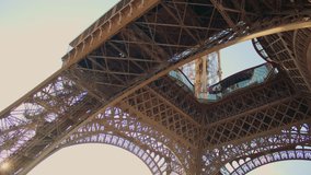 Looking up from under the Eiffel Tower, revealing its complex metalwork and sky above. Low angle shot from under the Eiffel tower. Intricate iron lattice structure of the Eiffel tower seen from below - Powered by Shutterstock - Get 15% off with code: PIKWIZARD15