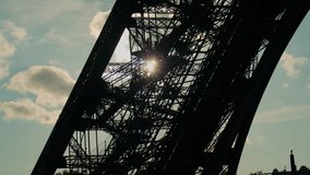 Eiffel Tower stair silhouette at sunset, with people, sun rays, and dramatic sky. Silhouettes of people walking on the Eiffel Tower's stairs during sunset, with sun shining through the iron lattice - Powered by Shutterstock - Get 15% off with code: PIKWIZARD15