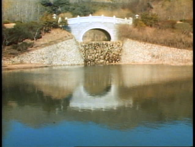 A scene of South Korea near Pusan with a lake and an elaborate bridge