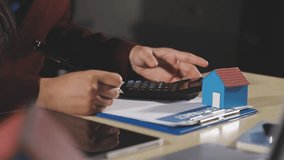 Woman holding house model in hand and calculating financial chart for investment to buying property. - Powered by Shutterstock - Get 15% off with code: PIKWIZARD15