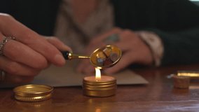 Close-up of a woman heating wax in a gold spoon on a candle, preparing to seal a letter with an antique seal. sending mail. - Powered by Shutterstock - Get 15% off with code: PIKWIZARD15