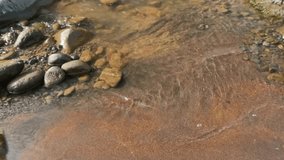 Slow motion ripples of river water surface on sandy and rocky river banks.Calm and peaceful atmosphere for relaxation. Ecology and environment concept. Footage 4K - Powered by Shutterstock - Get 15% off with code: PIKWIZARD15