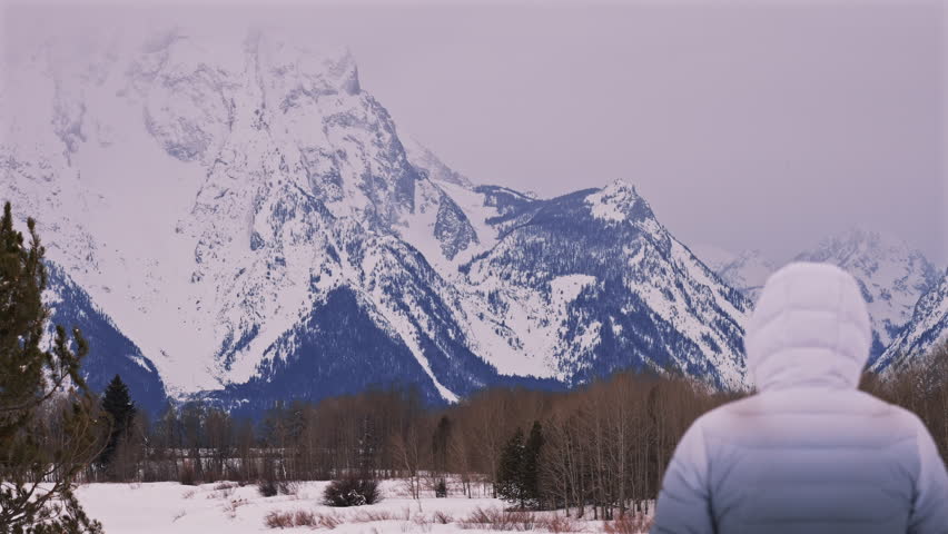 Man Walking Toward Snowy Teton Mountains 