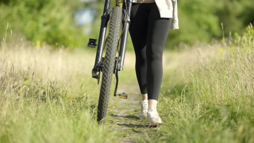 Woman walking their bicycle. Freedom and outdoor adventure. Cycling and cyclist lifestyles. Break during cycling trip. Cyclist healthy and leisurely activity away from urban hustle. Active recreation
