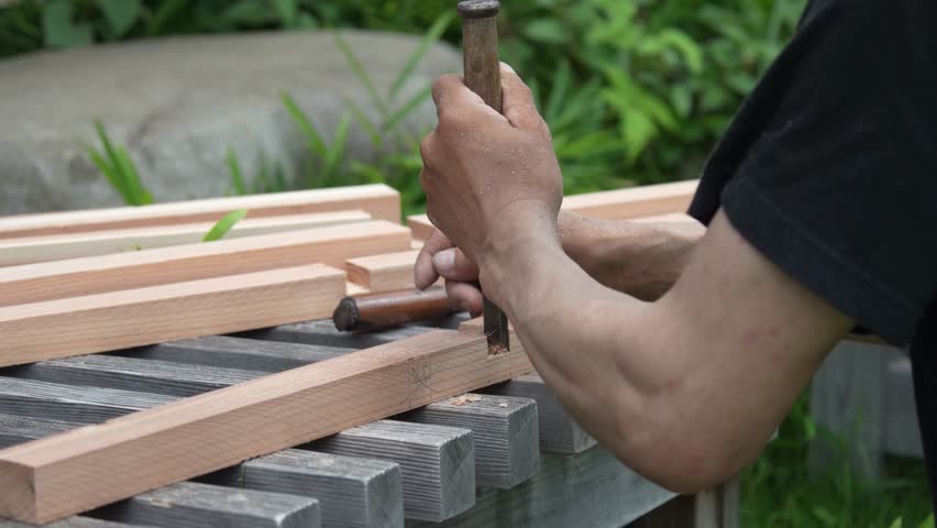 A man cutting wood with a chisel