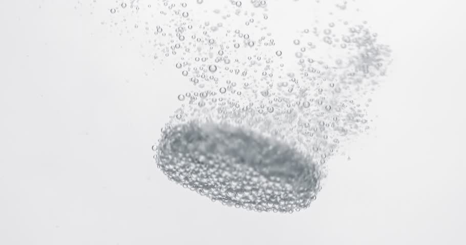Extreme Close-up effervescent tablet, pill bubbling underwater. Shot on super slow motion camera 1000 fps.
