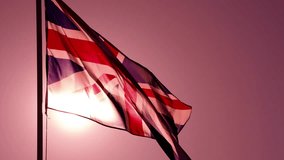 Sunlight Through the British Flag. The Big State Flag is illuminated by the sun and flutters epically in the wind against the rising sun. Slow Motion - Powered by Shutterstock - Get 15% off with code: PIKWIZARD15