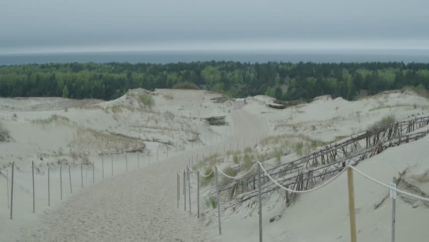 Curonian spit sand dune hill with view at distant forest and sea anamorphic 4k 60fps
