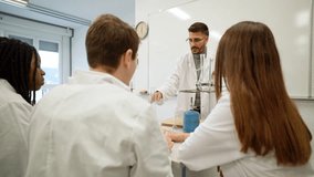 Science teacher leading hands-on experiment with attentive students - Powered by Shutterstock - Get 15% off with code: PIKWIZARD15